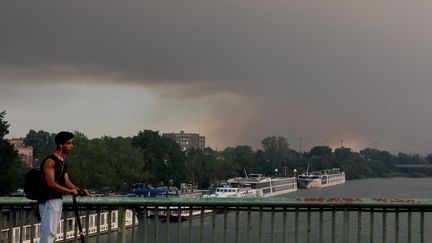 Le Palais des Papes, à Avignon, sous un nuage de fumée noire lors de l'incendie en cours dans le massif dit de la "Montagnette", situé à une dizaine de kilomètres, le 14 juillet 2022. (REY J?R?ME / MAXPPP)