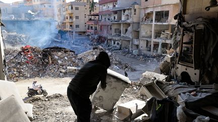 Un habitant dégage des décombres au milieu des destructions causées par les bombardements israéliens dans la ville de Tyr, dans le sud du Liban, le 28 novembre 2024, au lendemain de l'entrée en vigueur d'un cessez-le-feu entre Israël et le Hezbollah.