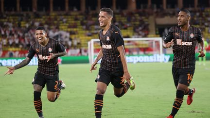 L'attaquant brésilien du Shakhtar, Pedrinho (au centre), célèbre son but lors du barrage aller de la Ligue des champions, face à l'AS Monaco, au stade Louis II, le 17 août 2021. (VALERY HACHE / AFP)