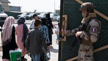 Un soldat français&nbsp;encadre l'embarquement de personnes évacuées à l'aéroport de Kaboul (Afghanistan), le 24 août 2021. (ETAT MAJOR DES ARMEES / AFP)