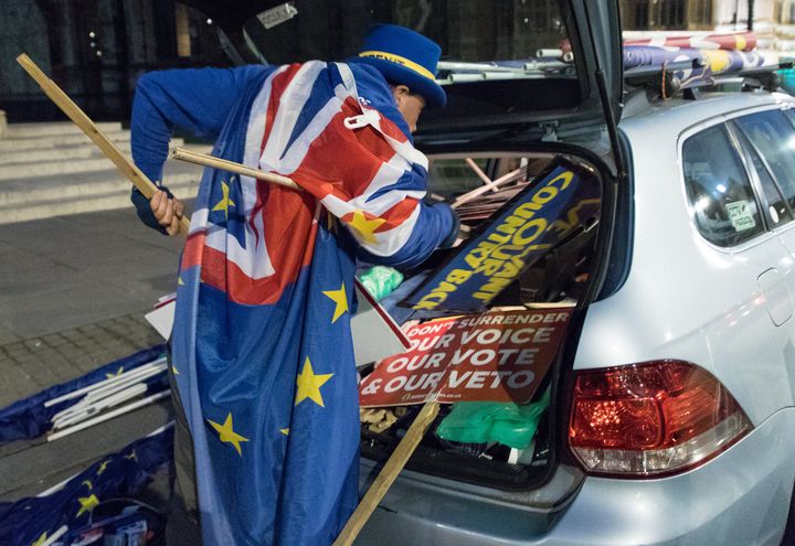 Steve Bray tente de ranger ses pancartes dans sa voiture, le 25 février 2019, à Londres (Royaume-Uni). (MARIE-VIOLETTE BERNARD / FRANCEINFO)