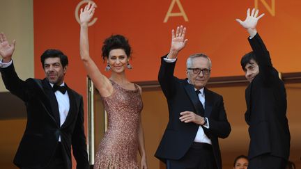 L'équipe du film Le Traître salue le public avant d'entrer dans le Palais des festivals pour la projection du film. (LOIC VENANCE / AFP)