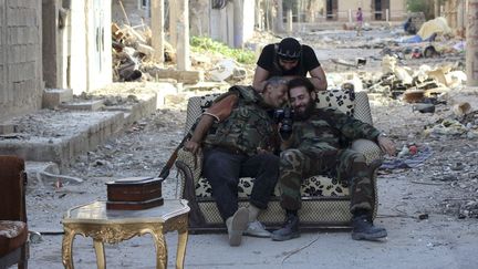 Des soldats de l'arm&eacute;e syrienne libre regardent des photos sur un appareil &agrave; Deir al-Zor (Syrie), le 14 juin 2013. (REUTERS)