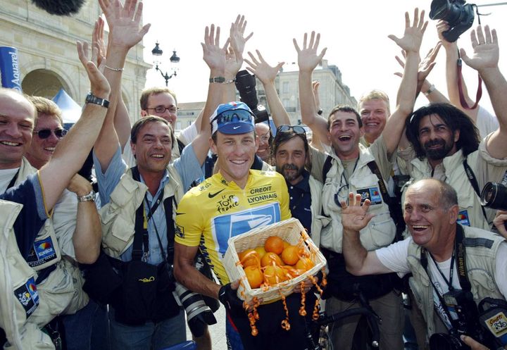 Lance Armstrong pose avec les photographes du Tour qui lui ont attribué le prix Orange du coureur le plus sympathique de la Grande Boucle, à Bordeaux, le 25 juillet 2003. (BERND THISSEN / DPA)