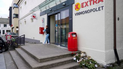 Des fleurs déposées devant le magasin où cinq personnes ont été tuées à Kongsberg (Norvège), cinq jours après l'attaque perpétrée le 13&nbsp;octobre 2021. (TERJE BENDIKSBY / NTB / AFP)