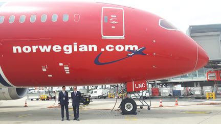 Le commandant de bord de Norwegian, Philippe Duforest, et le tout nouveau chef de base de Norwegian à Paris,&nbsp;Joost Smits,&nbsp;posent&nbsp;devant un appareil de la compagnie low-cost en mai 2017 à l'aéroport Chales de Gaulle. (ISABELLE RAYMOND / FRANCEINFO)