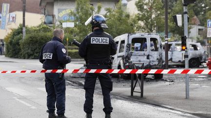 Deux membres des forces de l'ordre sur les lieux de la violente attaque contre&nbsp;des policiers, à Viry-Châtillon (Essonne), le 8 octobre 2016. (THOMAS SAMSON / AFP)