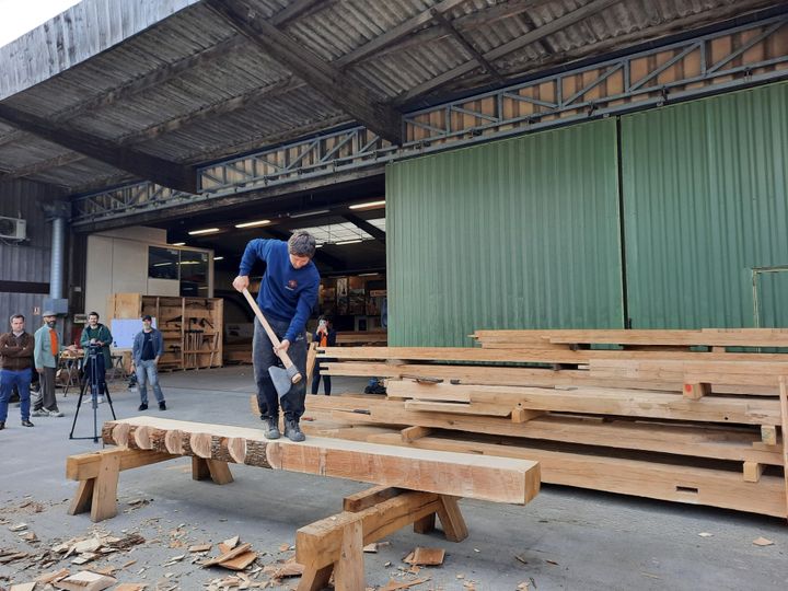 Matteo Pellegrino, charpentier indépendant, équarrit manuellement du bois, le 25 mai 2023 à Saint-Laurent-de-la-Plaine (Maine-et-Loire). (ANNE CHEPEAU)