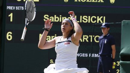 La Fran&ccedil;aise Marion Bartoli l&acirc;che sa raquette apr&egrave;s avoir remport&eacute; la finale du tournoi de tennis de Wimbledon face &agrave; l'Allemande Sabine Lisicki &agrave; Londres (Royaume-Uni), le 6 juillet 2013. (SUZANNE PLUNKETT / REUTERS)