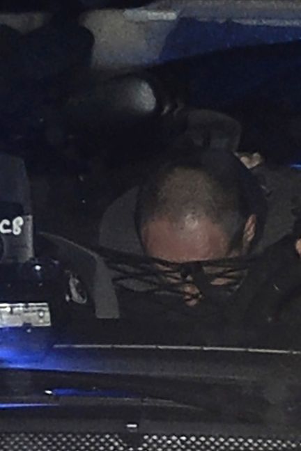 Hubert Caouissin lors d'un transfert, sous escorte policière, vers Pont-de-Buis (Finistère), le 8 mars 2017 (FRED TANNEAU / AFP)