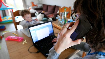 Une mère de famille pratique le télétravail. Photo d'illustration. (MAXPPP)