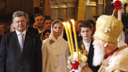 Le président ukrainien, Vladimir Porochenko, assiste avec sa famille à la messe de Pâques, dite par le patriarche Filaret (à droite), chef de l'Eglise orthodoxe ukrainienne, à la cathédrale Vladimirsky à Kiev le 12 avril 2015. (AFP - Anadolu Agency - Vladimir Shtanko)
