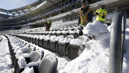 Des employ&eacute;s tentent de d&eacute;blayer les gradins du MetLife stadium &agrave; East Rutherford (New Jersey, Etats-Unis) apr&egrave;s une temp&ecirc;te de neige, le 22 janvier 2014. Le stade doit accueillir le Super Bowl le 2 f&eacute;vrier prochain. (JULIO CORTEZ / AP / SIPA)