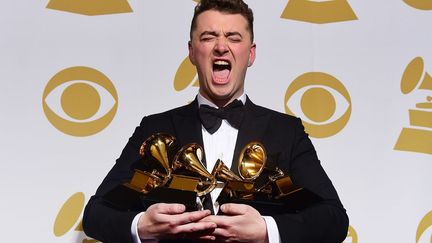 Le chanteur Sam Smith pose avec ses quatre troph&eacute;es apr&egrave;s la c&eacute;r&eacute;monie des Grammy Awards &agrave; Los Angeles (Californie, Etats-Unis), le 8 f&eacute;vrier 2015. (FREDERIC J. BROWN / AFP)