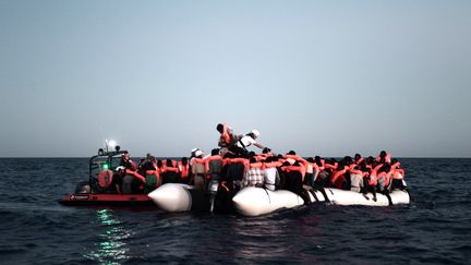 Des migrants à bord d'un canot pneumatique secourus par des membres de l'ONG SOS Méditerranée, le 9 juin 2018, en mer Méditerranée. (KARPOV / SOS MEDITERRANEE / AFP)