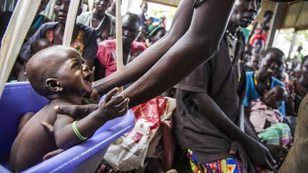 Une mère prend son enfant qui souffre de malnutrition, le 31 mai 2017, dans un centre de l'International Rescue Committee, à&nbsp;Panthau (Soudan du Sud). (ALBERT GONZALEZ FARRAN / AFP)