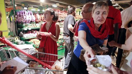 Des membres du collectif L'Appel et la Pioche (proche du Nouveau Parti anticapitaliste) organisent un pique-nique contre la baisse du pouvoir d'achat&nbsp;dans un supermarch&eacute; parisien, le 4 juin 2011. (FRANÇOIS GUILLOT / AFP)