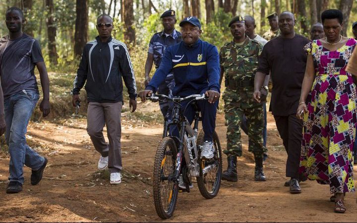 Le président Pierre Nkurunziza arrive, à vélo, à son bureau de vote dans son village natal de Buye, le 21 juillet 2015. (Photo AFP/Philip Moore)