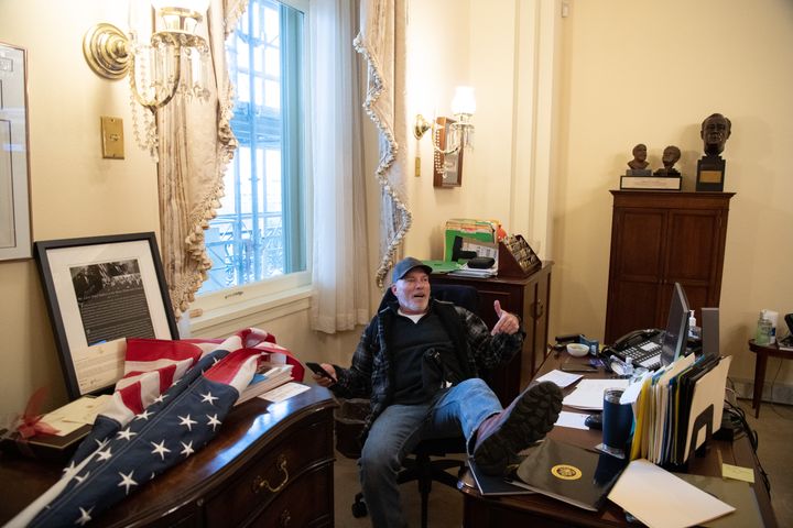 Richard Barnett, un pied sur le bureau de Nancy Pelosi, la présidente démocrate de la Chambre des représentants,&nbsp;le 6 janvier 2021, lors de l'envahissement du Capitole par des partisans de Donald Trump à Washington. (SAUL LOEB / AFP)