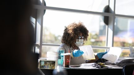 Une personne comptabilise des bulletins de vote pour l'élection présidentielle américaine, à Atlanta, en Géorgie, le 4 novembre 2020. (JESSICA MCGOWAN / GETTY IMAGES NORTH AMERICA / AFP)