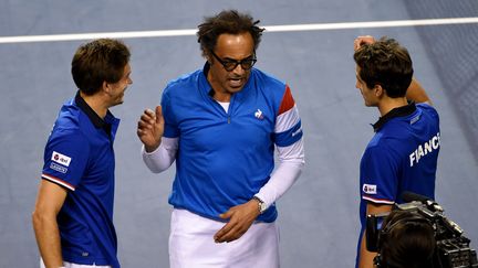 Le capitaine de l'équipe de France de tennis Yannick Noah entouré de&nbsp;Nicolas Mahut et de&nbsp;Pierre-Hugues Herbert le 4 février 2017 à Tokyo.&nbsp; (TORU YAMANAKA / AFP)