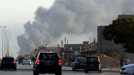 De la fum&eacute;e visible &agrave; proximit&eacute; de l'a&eacute;roport international de Tripoli (Libye), o&ugrave; des milices rivales s'affrontent, le 24 juillet 2014. (MAHMUD TURKIA / AFP)