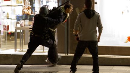 Un homme est arr&ecirc;t&eacute; par un policier en tenue, le 13 mai 2013, &agrave; Paris, apr&egrave;s les c&eacute;l&eacute;brations du titre du PSG. (VINCENT WARTNER / 20 MINUTES / SIPA)