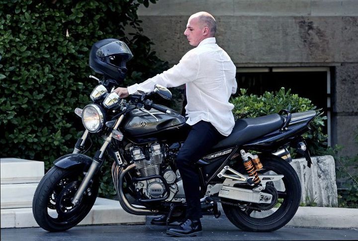 Yanis Varoufakis, descend de sa moto, en arrivant aux bureaux du Premier ministre (21 juin 2015). (ANGELOS TZORTZINIS / AFP)