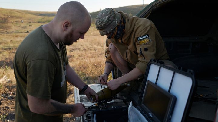 Des soldats ukrainiens équipent un drone kamikaze d'un dispositif explosif dans une zone d'entraînement le 25 septembre 2024 à Droujkivka, en Ukraine. (PIERRE CROM / GETTY IMAGES EUROPE)