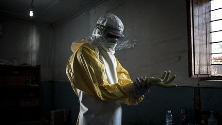 Un agent de santé met son équipement de protection avant d'entrer dans un centre de traitement contre Ebola dans le nord-est de la RDC en novembre 2018 (JOHN WESSELS / AFP)