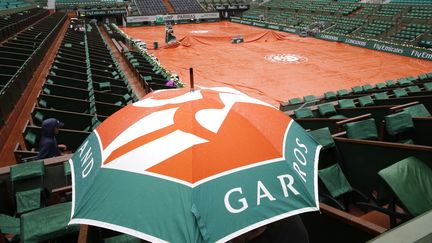 Les b&acirc;ches ont &eacute;t&eacute; d&eacute;ploy&eacute;es sur le court central de Roland-Garros, dimanche 31 mai 2015.&nbsp; (JEAN-PAUL PELISSIER / REUTERS / )