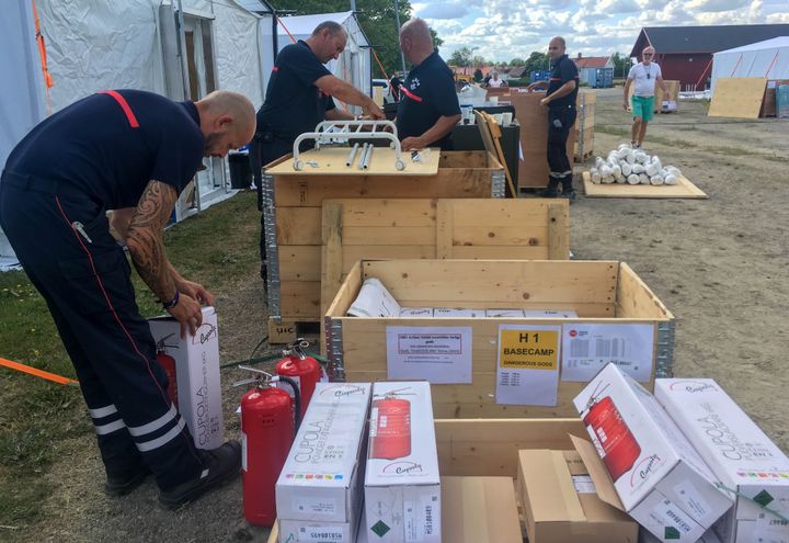 Des pompiers français installent leurs affaires dans le camp de base de Färila, le 24 juillet 2018. (ELISE LAMBERT / FRANCEINFO)