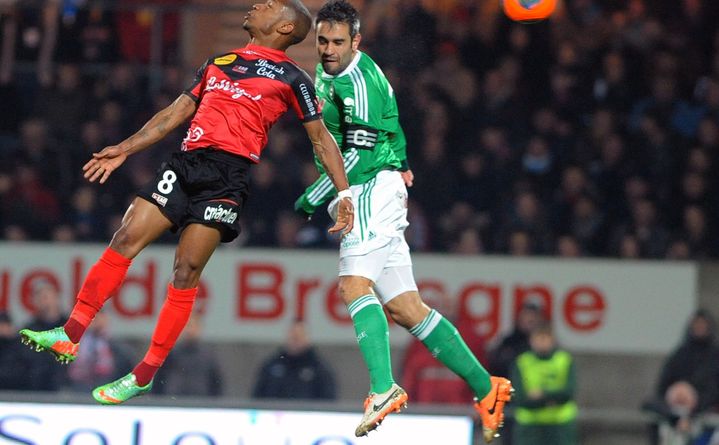 Le Guingampais Claudio Beauvue (en rouge) &agrave; la lutte avec le St&eacute;phanois Lo&iuml;c Perrin sur un ballon a&eacute;rien, le 11 janvier 2014.&nbsp; (FRED TANNEAU / AFP)