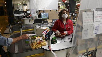 Une employée à la caisse d'un magasin situé dans le centre-ville de Strasbourg (Bas-Rhin), le 19 mars 2020. (FREDERICK FLORIN / AFP)