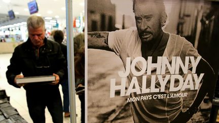 Un amateur de Johnny Hallyday achète un exemplaire du disque posthume du chanteur, le 19 octobre 2018 au supermarché Leclerc de Reims (Marne). (FRANCOIS NASCIMBENI / AFP)