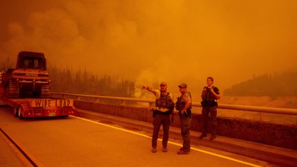 Des forces de l'ordre et des pompiers attendent sur le pont Entreprise pour pouvoir approcher le feu Bear à Oroville, en Californie, le 9 septembre 2020.&nbsp; (JOSH EDELSON / AFP)