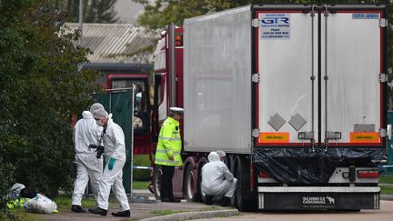 Des enquêteurs à côté du camion qui transportait 39 corps, au Royaume-Uni, le 23 octobre 2019. (BEN STANSALL / AFP)