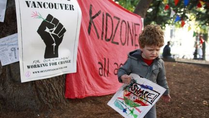 Pendant que les parents manifestent leur mécontentement en occupant diverses villes au Canada, les enfants dans la « kid zone » de Vancouver font de l’art. (AFP/Getty Images/JEFF VINNICK)