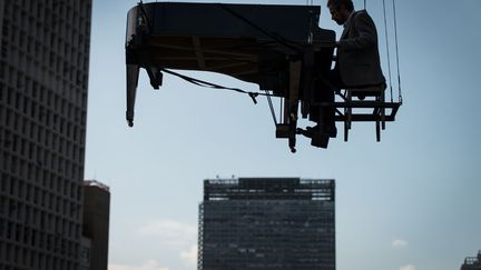 Le pianiste br&eacute;silien Ricardo de Castro Monteiro joue suspendu dans les airs &agrave; Sao Paulo (Br&eacute;sil), le 6 mai 2012. (YASUYOSHI CHIBA / AFP)