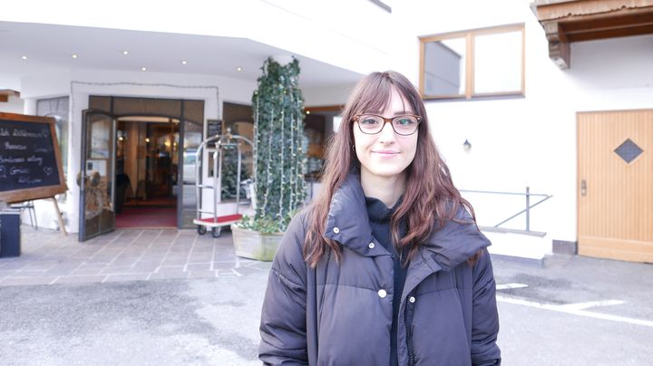 Marie Cabiro devant l'entrée de l'hôtel Schwarzbrunn à Stans :&nbsp;"On est passé de 50 personnes à des groupes maintenant de 30-35 personnes."&nbsp;&nbsp; (Photo Emmanuel Langlois / franceinfo)