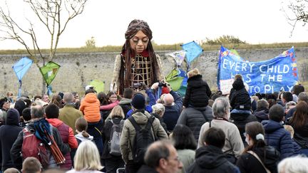 La marionnette Amal haute de 3,50 m le 17 octobre 2021 dans une rue de Calais, l'une des dernières étapes de son périple de 8000 km à travers l'Europe pour sensibiliser à la cause des migrants. (FRANCOIS LO PRESTI / AFP)