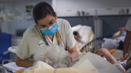 Une infirmière masquée fait une prise de sang à une personne âgée, le 4 juillet 2022, à Perpignan (Pyrénées-Orientales). Dès le&nbsp;1er août, le gouvernement ne pourra plus imposer le port du masque, y compris dans les établissements hospitaliers. (ARNAUD LE VU / HANS LUCAS / AFP)