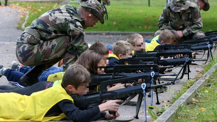 Lors d&rsquo;ateliers "d&eacute;couvertes" &agrave; l&rsquo;&eacute;cole &eacute;l&eacute;mentaire de Flastroff (Moselle), les &eacute;l&egrave;ves d'une &eacute;cole primaire manipulent des fusils d&rsquo;assaut Famas et des pistolets automatiques, le 9 octobre 2015. (  MAXPPP)