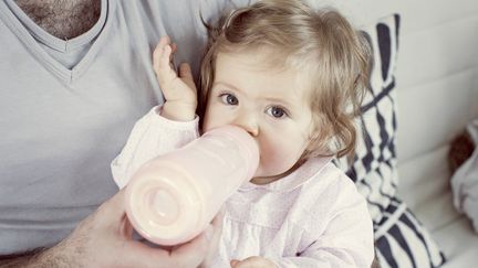 Un homme donne le biberon à son bébé. (ANNE-SOPHIE BOST / MAXPPP)