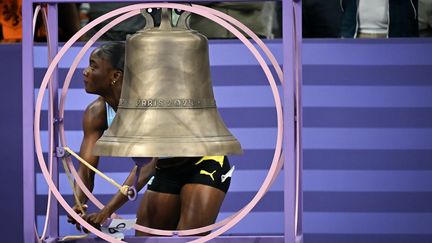 La championne olympique du 100m Julien Alfred sonne la cloche au Stade de France, à Saint-Denis, le 3 août 2024. (ANDREJ ISAKOVIC / AFP)