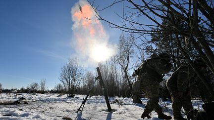 Ukrainian soldiers fire a mortar during military exercises in the Zhytomyr region, January 30, 2024. (SERGEI SUPINSKY / AFP)