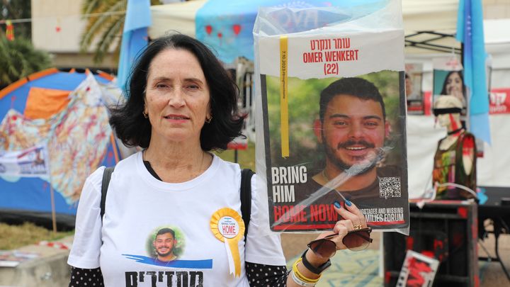 Dorit brandit une pancarte à l'effigie d'un de ses anciens élèves, retenu en otage, à Tel-Aviv (Israël), le 6 décembre 2023. (ROBIN PRUDENT / FRANCEINFO)