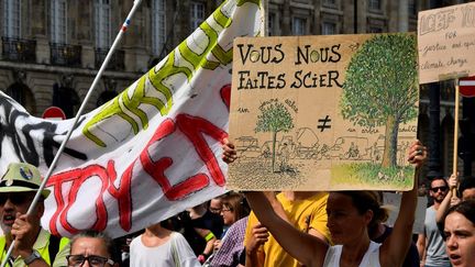BORDEAUX.&nbsp;Une manifestante brandit une pancarte sur laquelle on peut lire "vous nous faites scier", samedi 21 septembre 2019. (GEORGES GOBET / AFP)