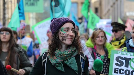 Une membre d'Extinction Rebellion marche à Glasgow (Royaume-Uni) pour dénoncer le "greenwashing", le 3 novembre 2021. (CAMILLE ADAOUST / FRANCEINFO)