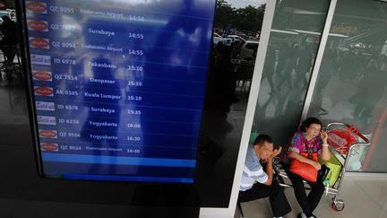 Un couple patiente &agrave; l'a&eacute;roport de Jakarta (Indon&eacute;sie), le 28 d&eacute;cembre 2014. (BIMA SAKTI / AFP)